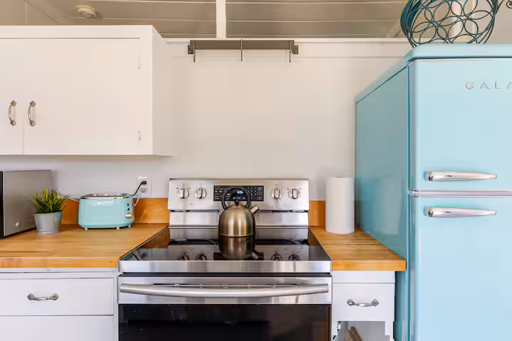 Carriage House kitchen with a soft blue refrigerator, matching toaster and full-size stove.